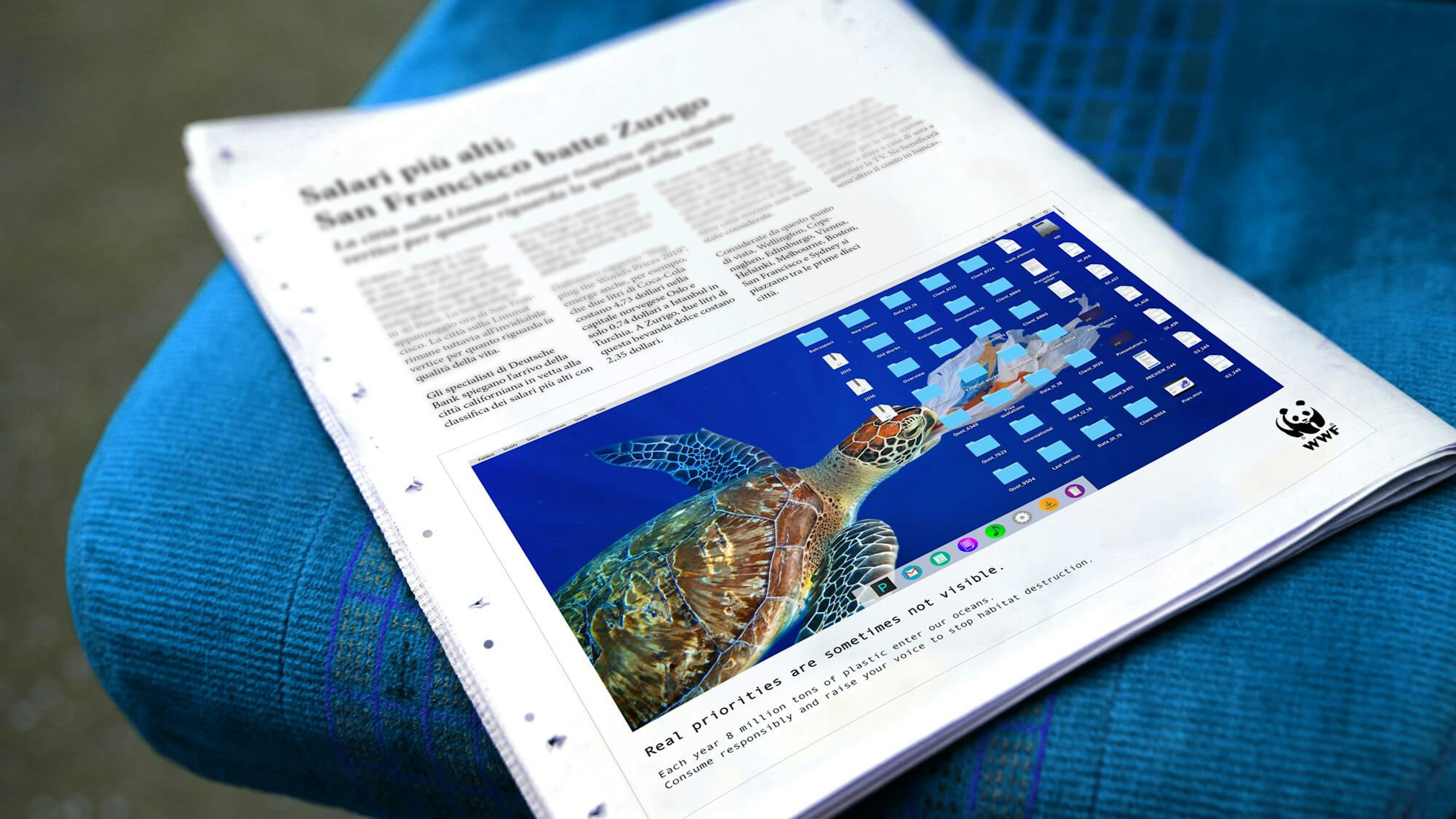 A newspaper open on a blue seat features a WWF ad showing a turtle tangled in plastic, displayed as a desktop background. The ad emphasizes the importance of focusing on real environmental issues, highlighting the dangers of ocean pollution.
