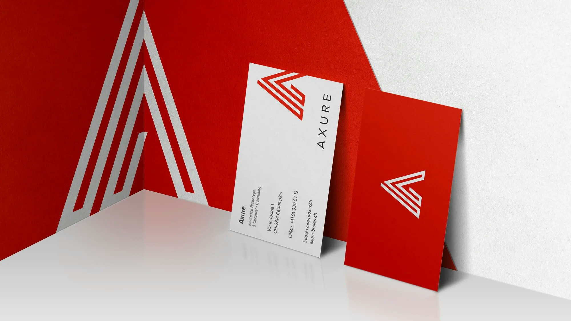 Axure branding materials. Displays business cards with the Axure logo. A card showing contact information, the back is red with a white logo. The design emphasizes professionalism and modernity, reflecting corporate identity.